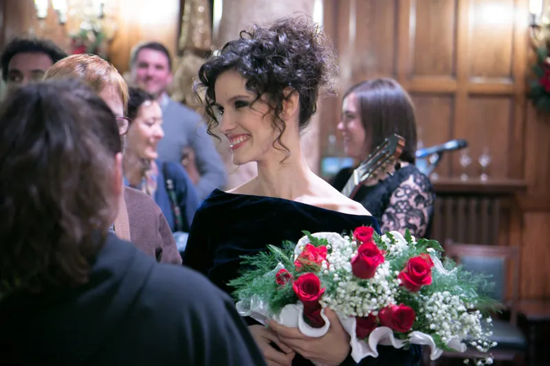 Alicia Sevilla saludando al público con un ramo de rosas